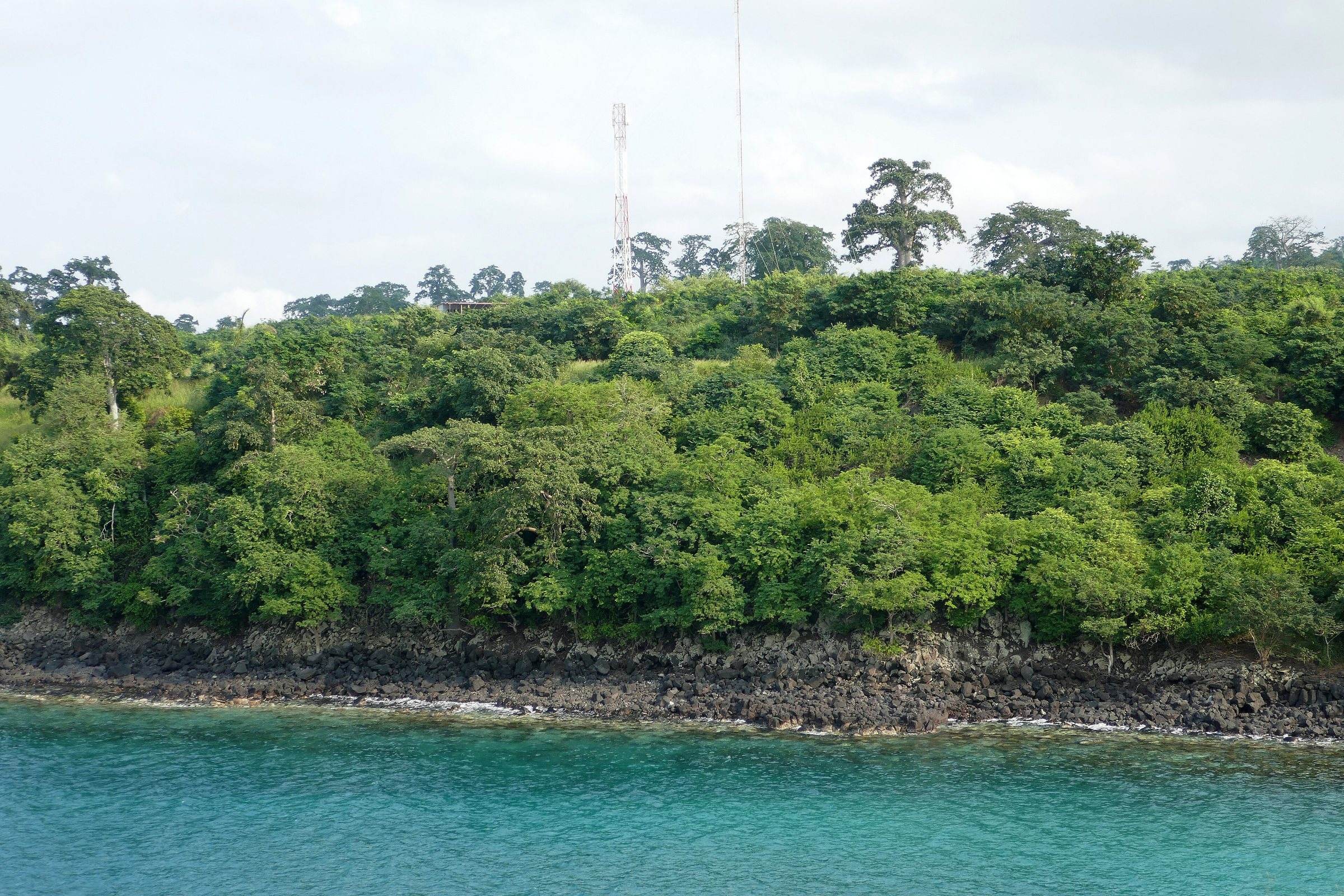 Turquoise water at the foot of a forested headland at Lagoa Azul