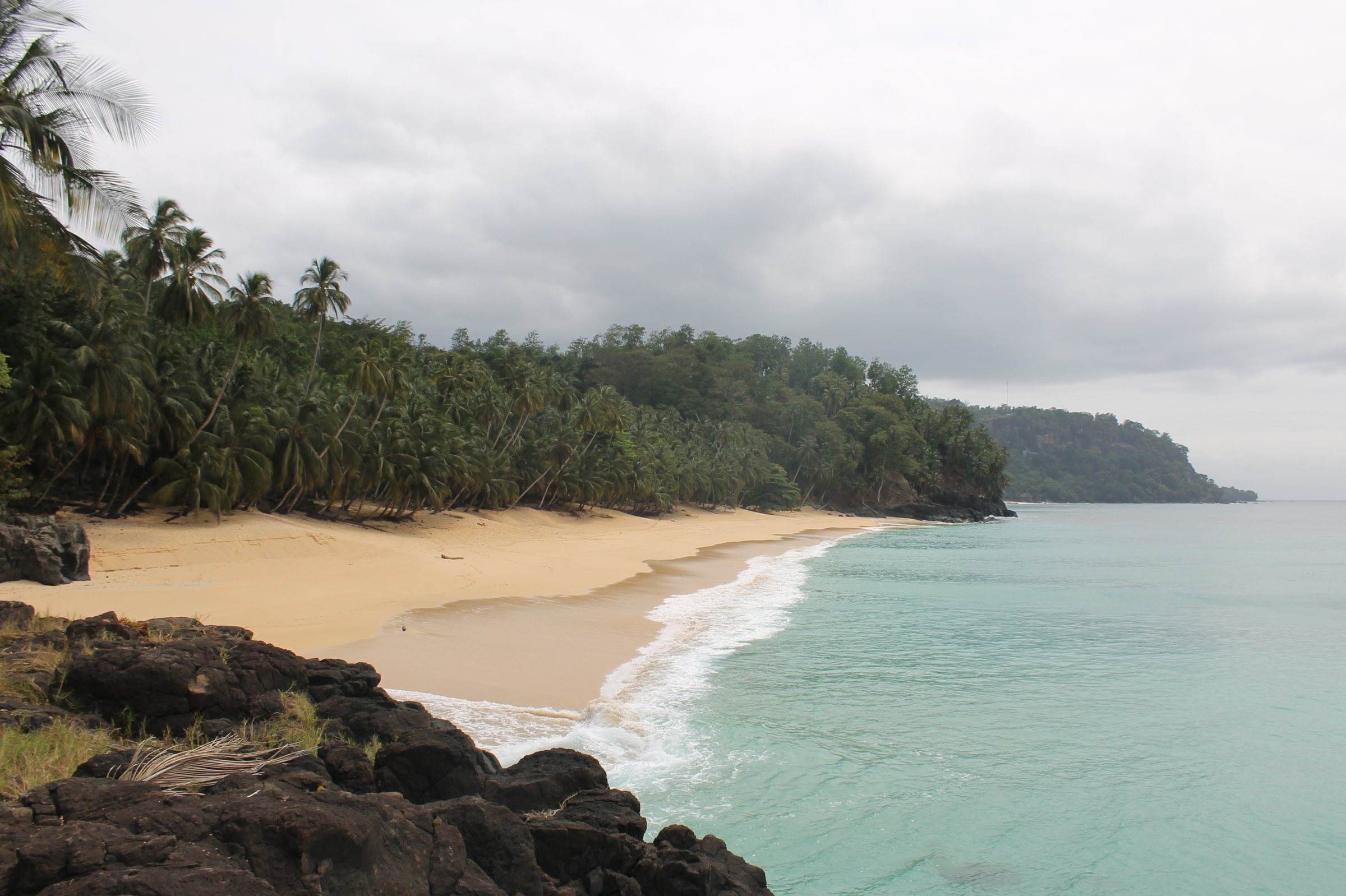 Turquoise water and a curve of pale sand backed by palms at Praia Macaco, Príncipe