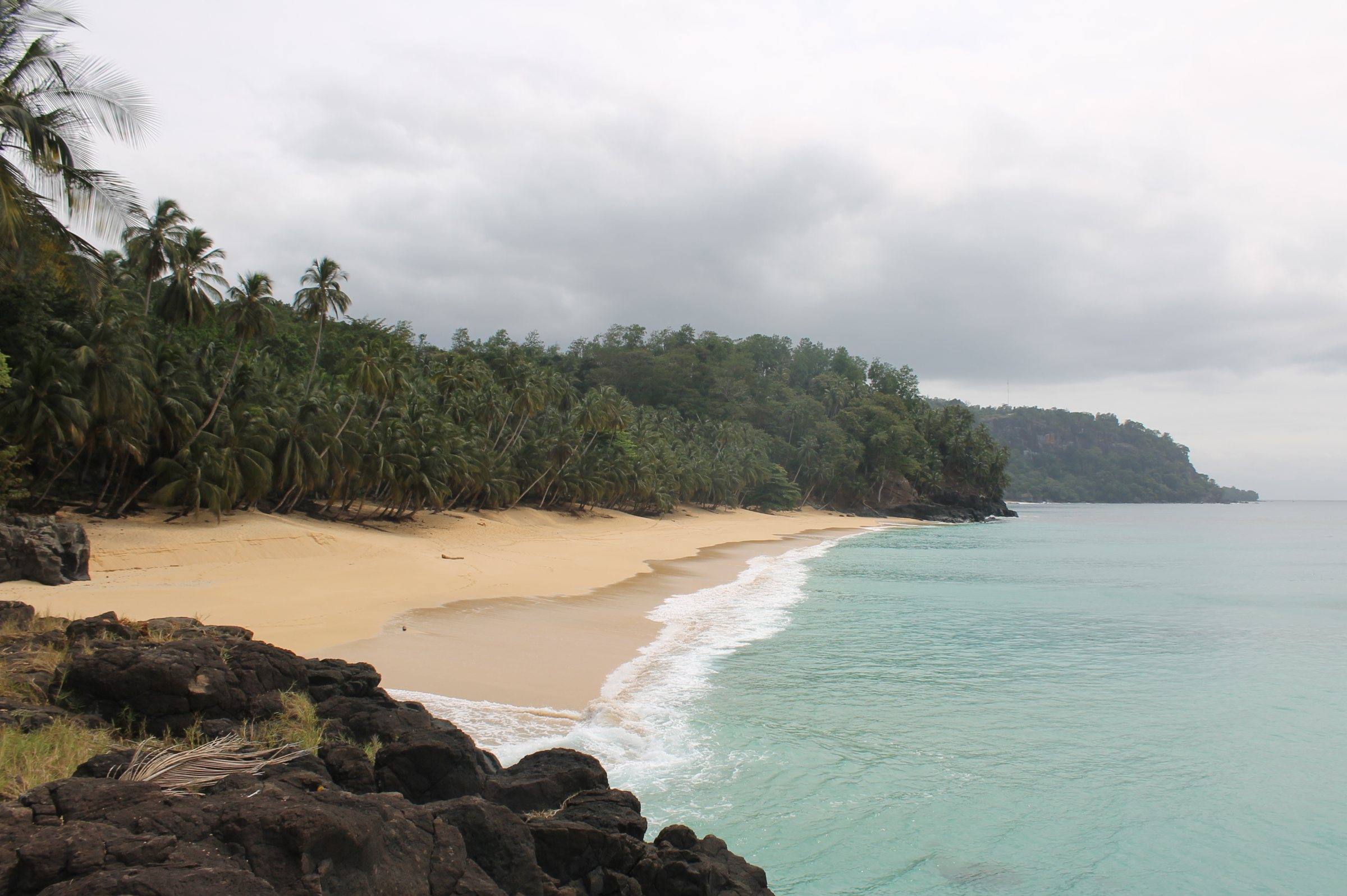 Turquoise water and a curve of pale sand backed by palms at Praia Macaco, Príncipe
