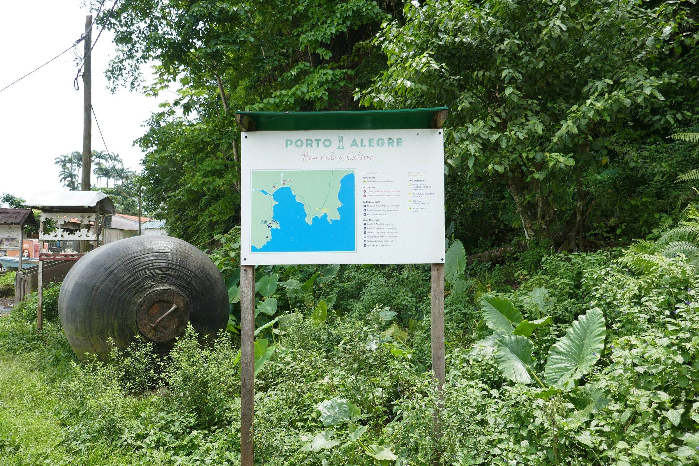The entrance to Porto Alegre in southern São Tomé, with a village map board beside the road