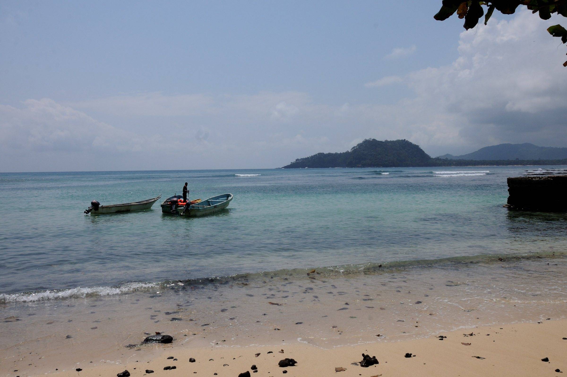 Small wooden fishing boats moored off the beach at Praia Inhame in the far south of São Tomé