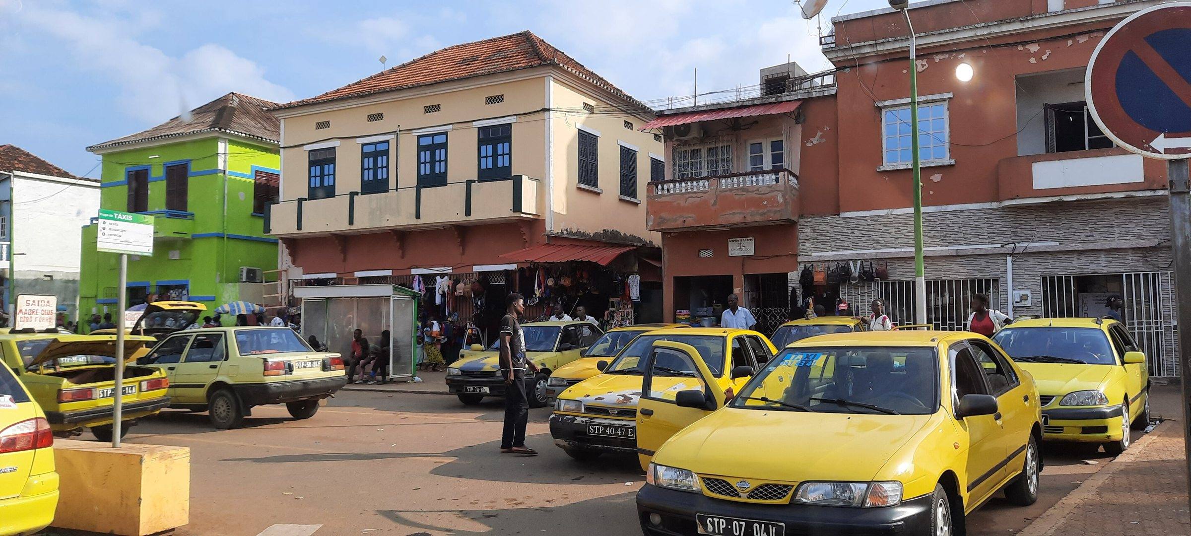 Yellow taxis lined up in the centre of São Tomé city
